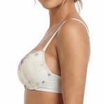 Woman wearing a white bra with floral lace details on a white background