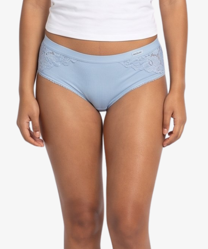 A woman modeling a  light blue high-waisted briefs against a plain light gray background.
