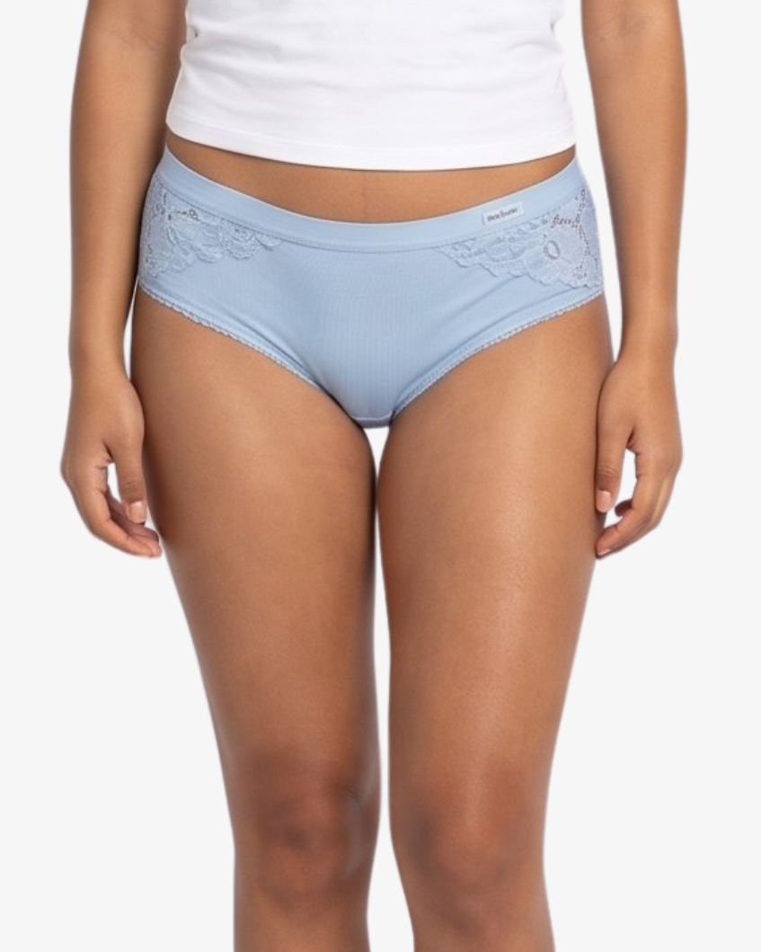A woman modeling a  light blue high-waisted briefs against a plain light gray background.