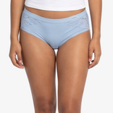 A woman modeling a  light blue high-waisted briefs against a plain light gray background.