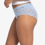 A woman modeling a  light blue high-waisted briefs against a plain light gray background.