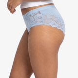 A woman modeling a  light blue high-waisted briefs against a plain light gray background.