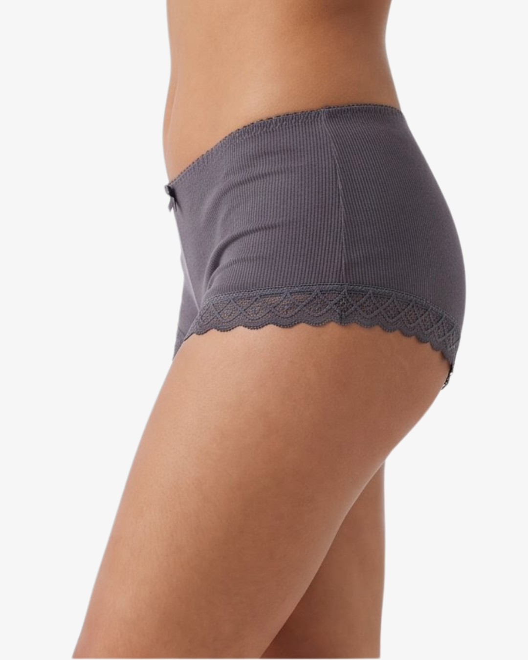 A close-up side view of a model wearing ribbed boyleg  grey underwear with a scalloped lace hem against a plain light background.