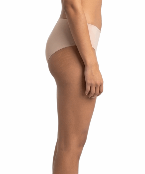 Woman wearing a beige shapewear garment on a white background