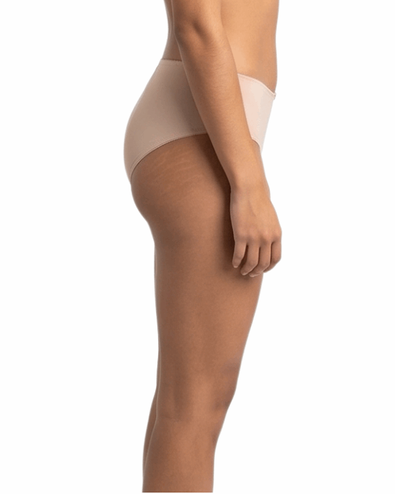 Woman wearing a beige shapewear garment on a white background