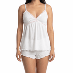Woman wearing a white lace camisole and matching shorts on a white 