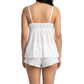 Woman wearing a white lace camisole and matching shorts on a white 