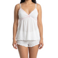 Woman wearing a white lace camisole and matching shorts on a white 