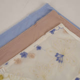 Three folded fabric samples with floral patterns on a light background