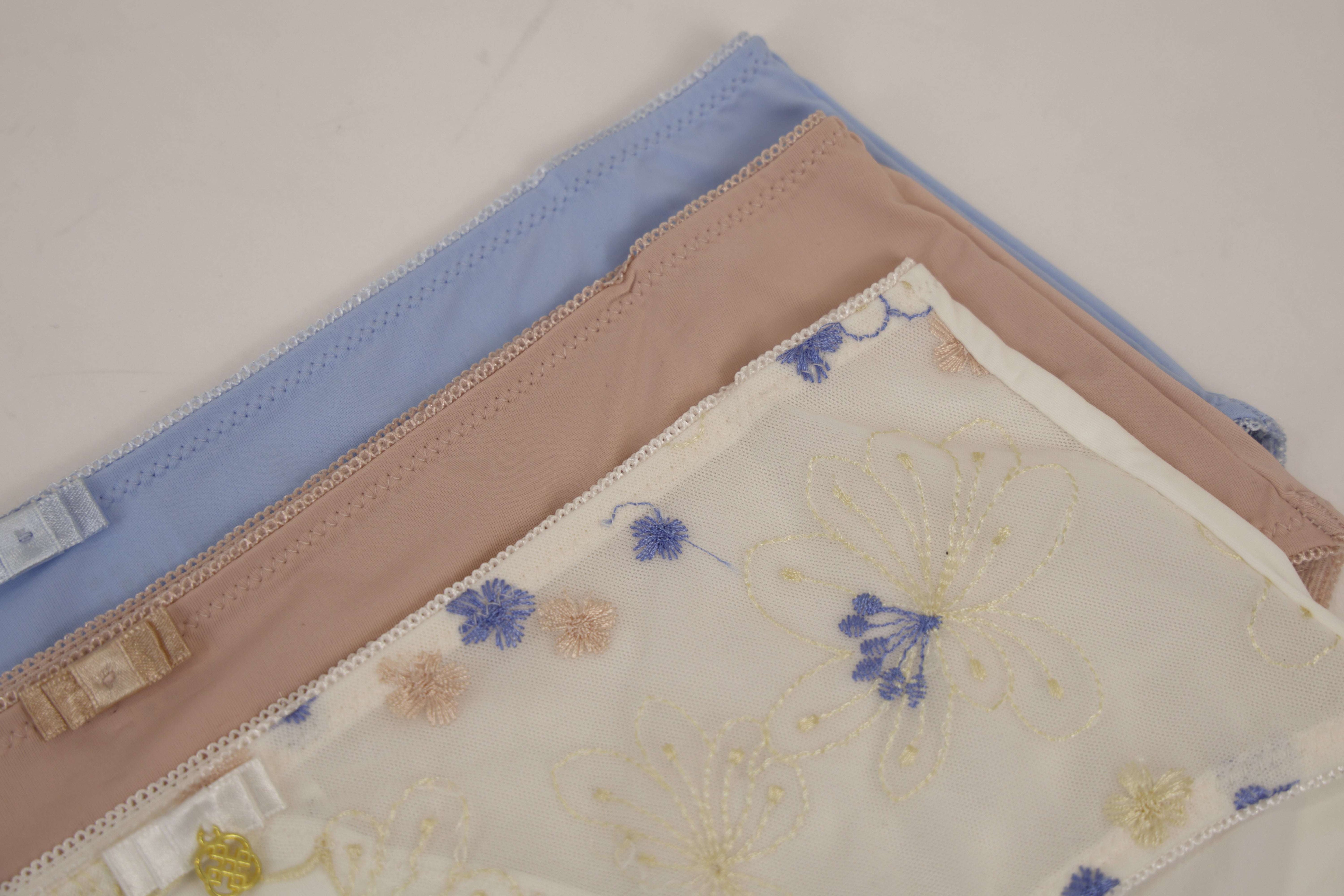 Three folded fabric samples with floral patterns on a light background