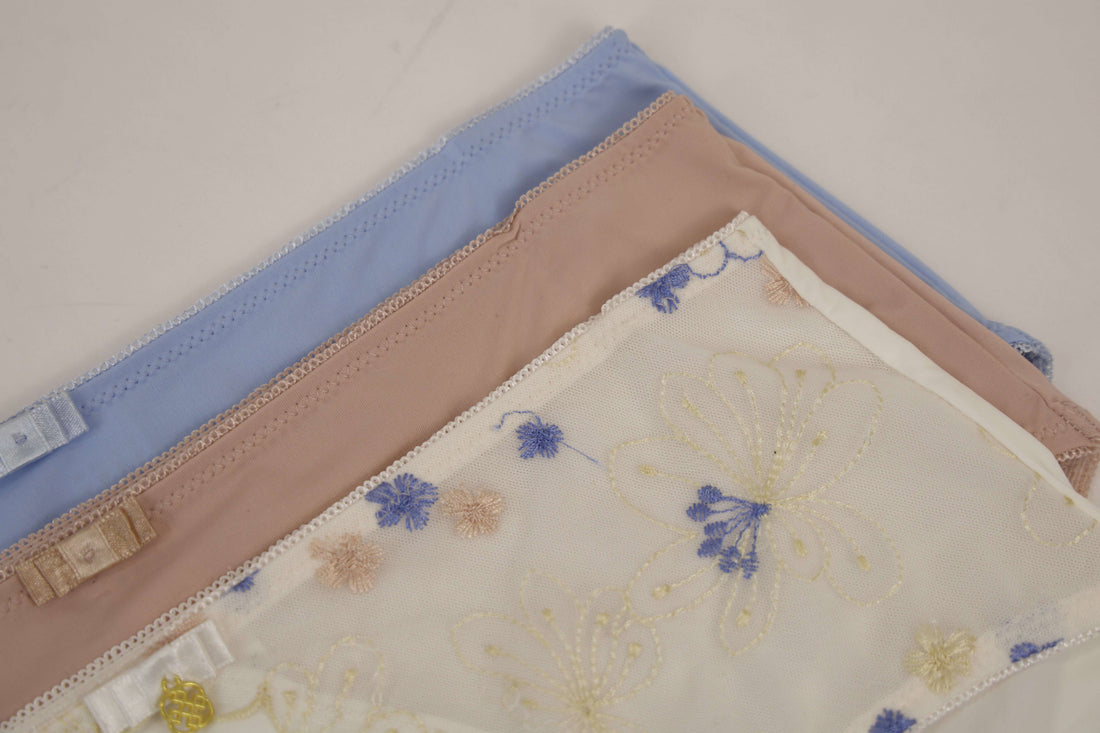 Three folded fabric samples with floral patterns on a light background