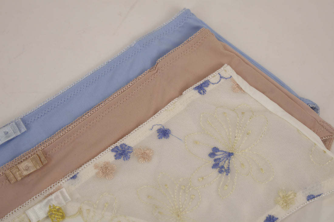 Three folded fabric samples with floral patterns on a light background