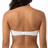 Woman wearing a white strapless bra on a white background