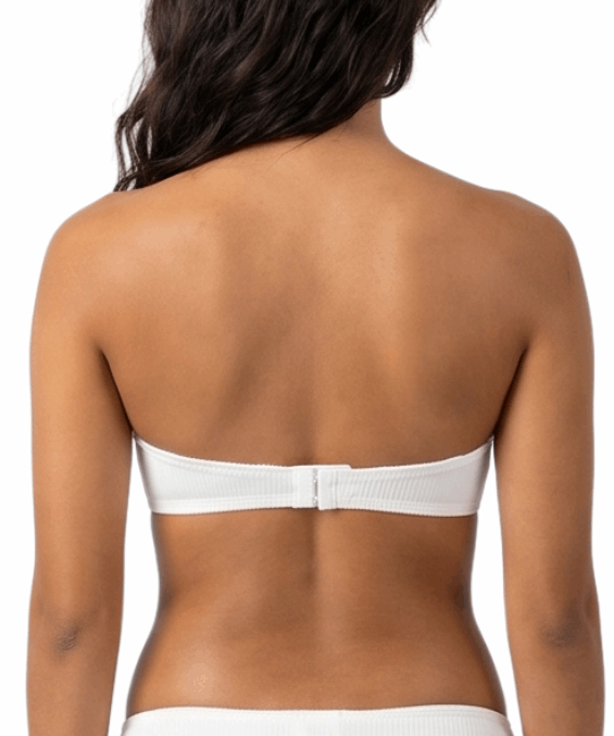 Woman wearing a white strapless bra on a white background