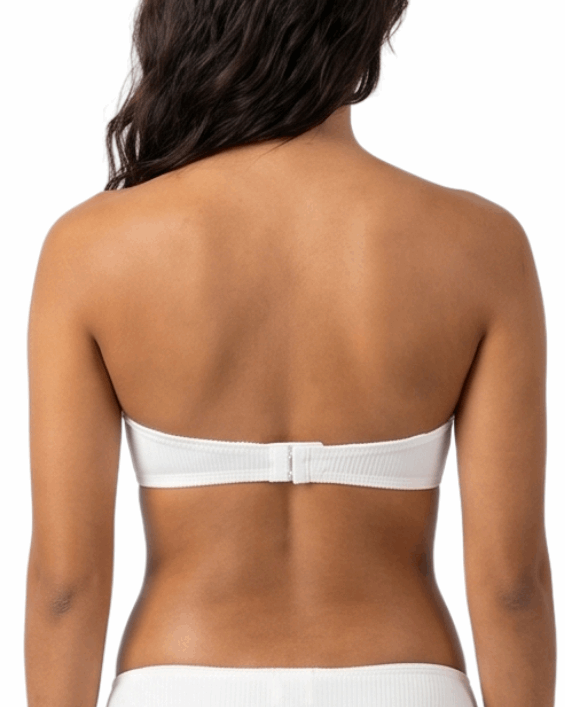 Woman wearing a white strapless bra on a white background