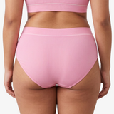 A woman modeling a ribbed high-waisted bikini against a light gray studio background.
