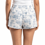 Woman wearing a white tank top and floral shorts on a white background