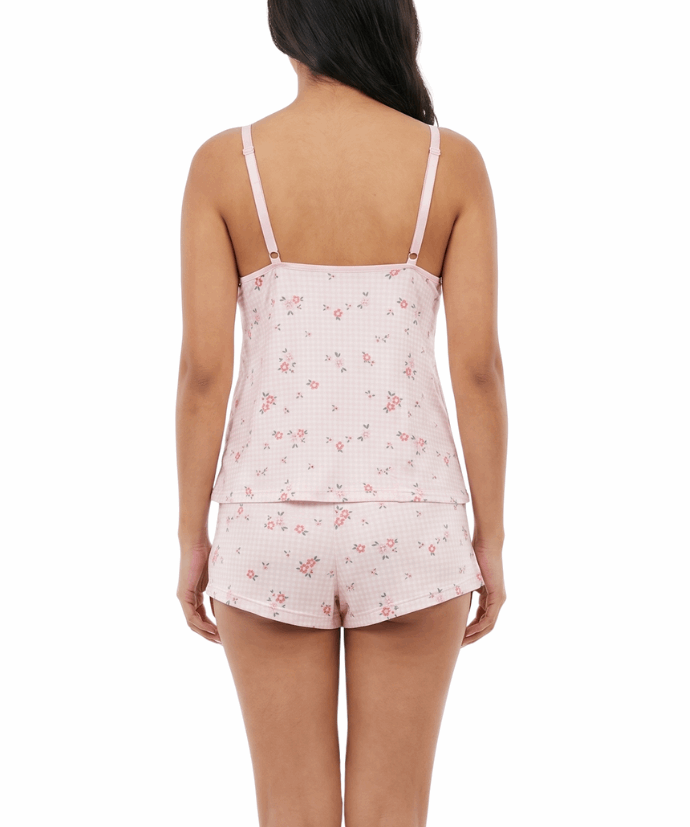 Woman wearing a pink floral pajama set on a white background