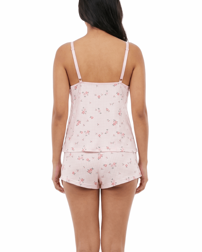 Woman wearing a pink floral pajama set on a white background