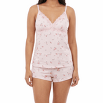 Woman wearing a pink floral pajama set on a white background