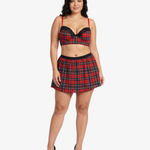 Plus size woman wearing a red and black plaid top and skirt on a white background