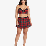Plus size woman wearing a red and black plaid top and skirt on a white background