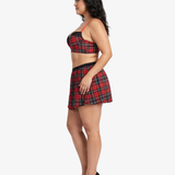 Plus size woman wearing a red and black plaid top and skirt on a white background