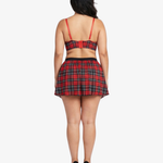 Plus size woman wearing a red and black plaid top and skirt on a white background