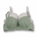 Green bra with lace details and solid white bra on a white background