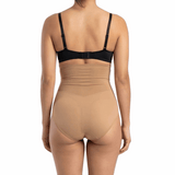 Woman wearing a black bra and mocha shapewear on a white background