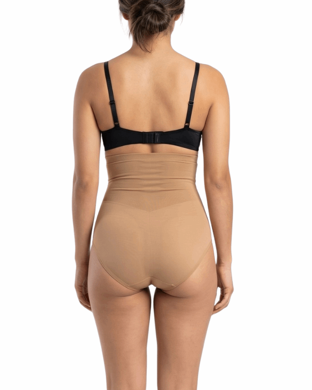 Woman wearing a black bra and mocha shapewear on a white background