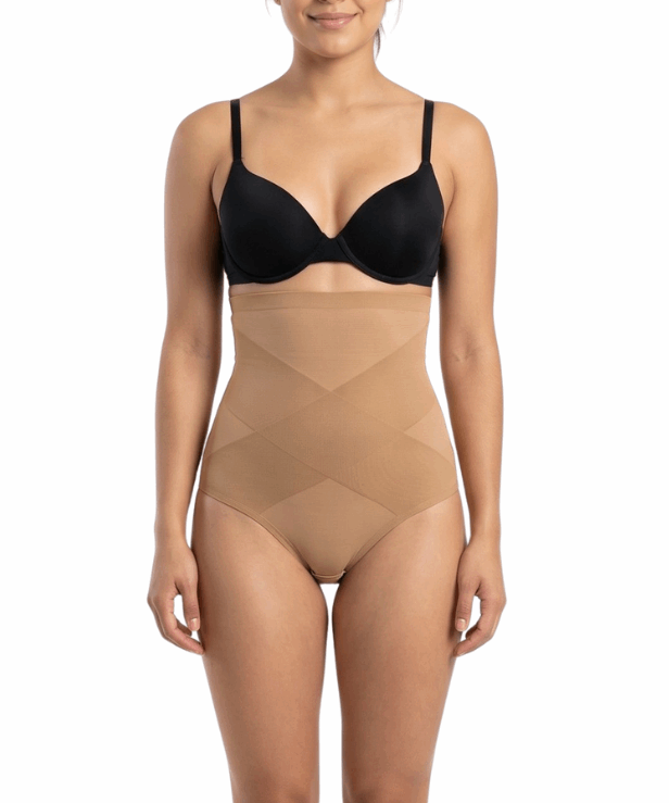 Woman wearing a black bra and mocha shapewear on a white background