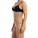 Woman wearing a black bra and mocha shapewear on a white background