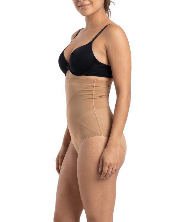 Woman wearing a black bra and mocha shapewear on a white background