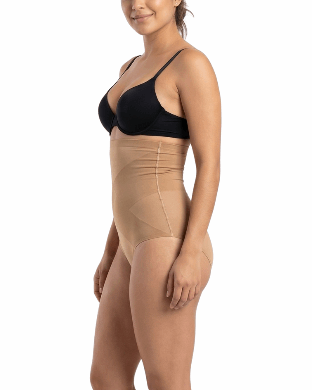 Woman wearing a black bra and mocha shapewear on a white background