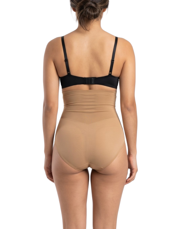 Woman wearing a black bra and mocha shapewear on a white background