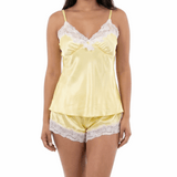 Woman wearing a yellow satin nightgown with lace trim on a white background
