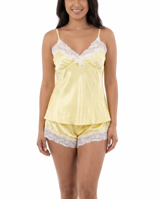 Woman wearing a yellow satin nightgown with lace trim on a white background