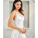 Woman wearing a white lace nightgown in a neutral setting