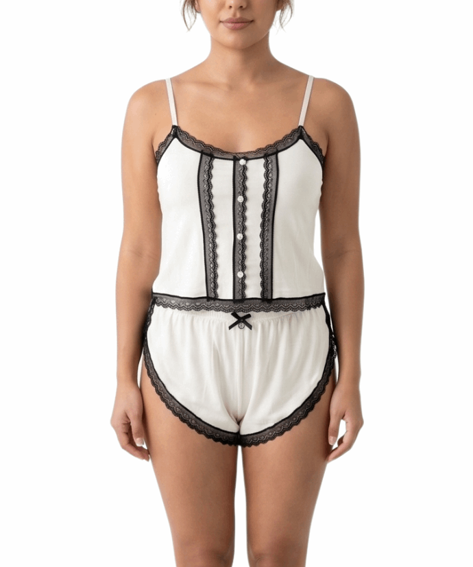 Woman wearing a cream lace-trimmed pajama set on a white background