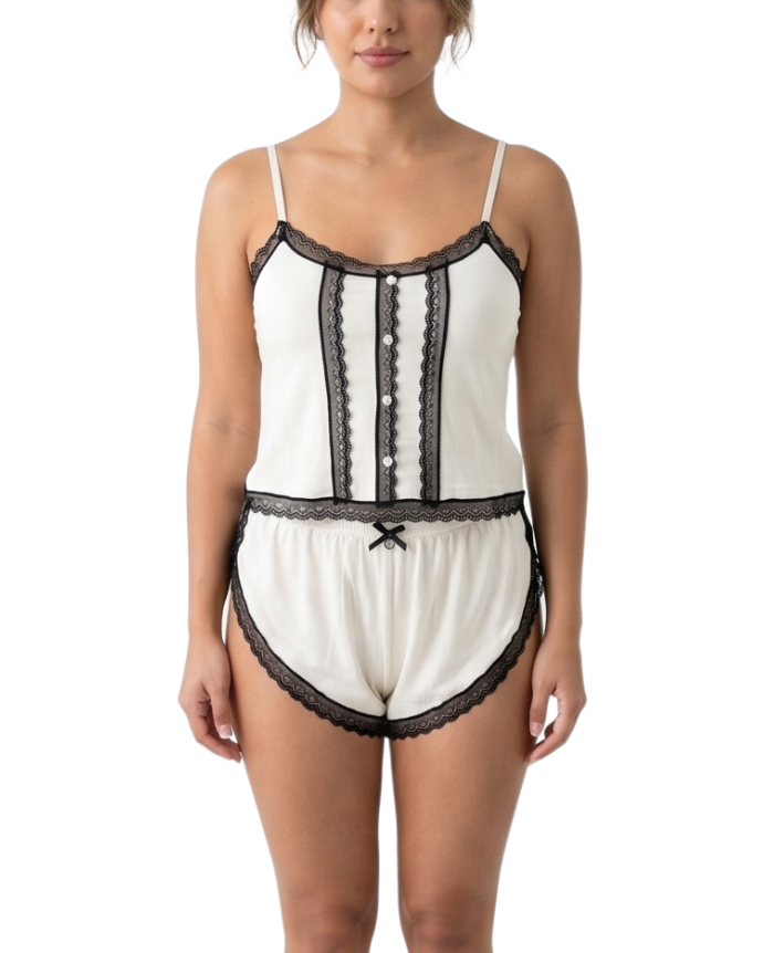 Woman wearing a cream lace-trimmed pajama set on a white background